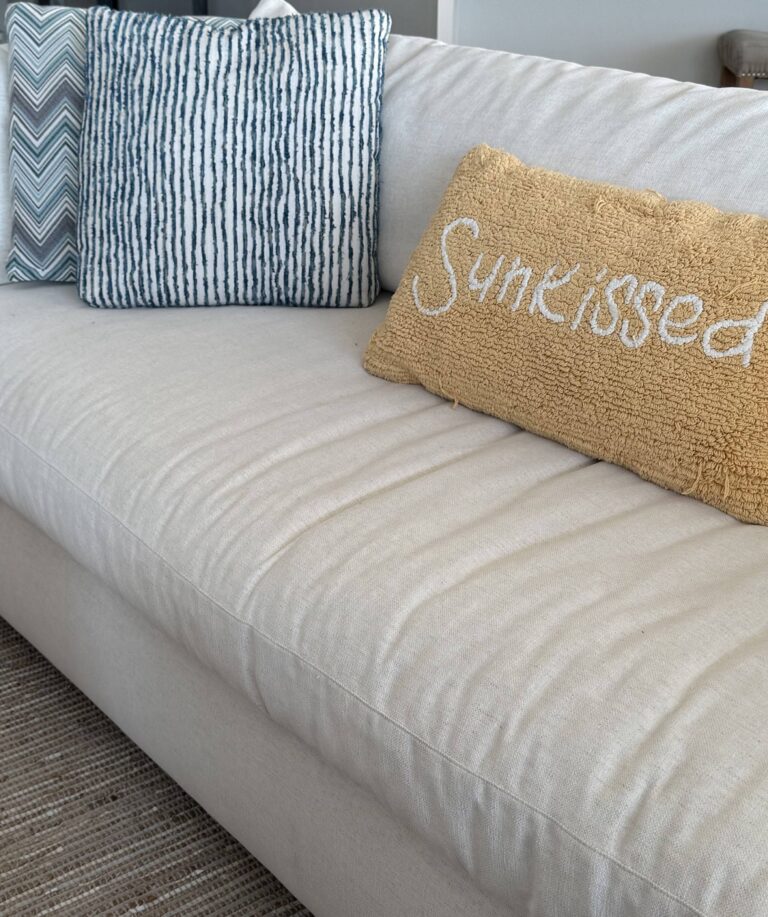 image of a white sofa with a yellow pillow that says sunkissed